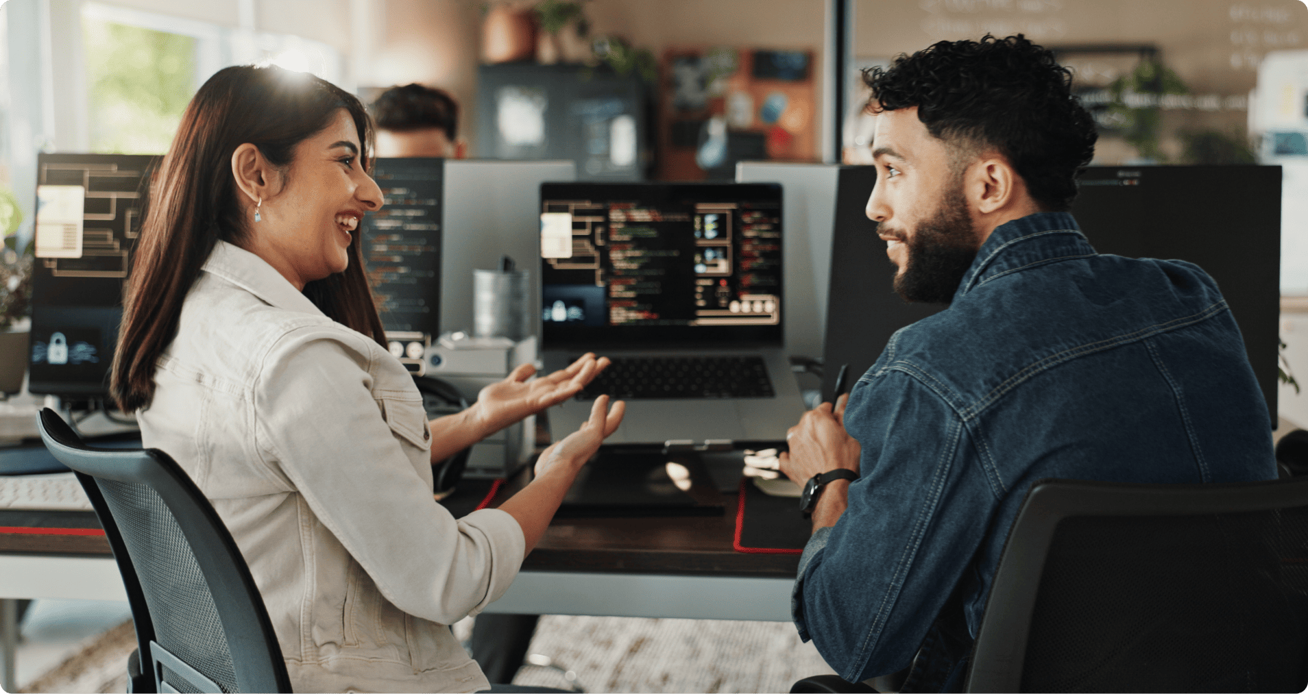 Two people smiling observing code on a computer screen